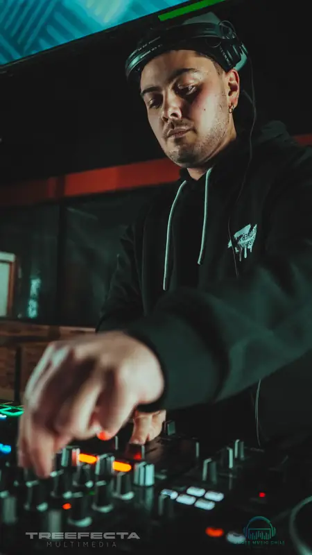 DJ con audífonos ajustando la mesa de mezcla durante una sesión en vivo